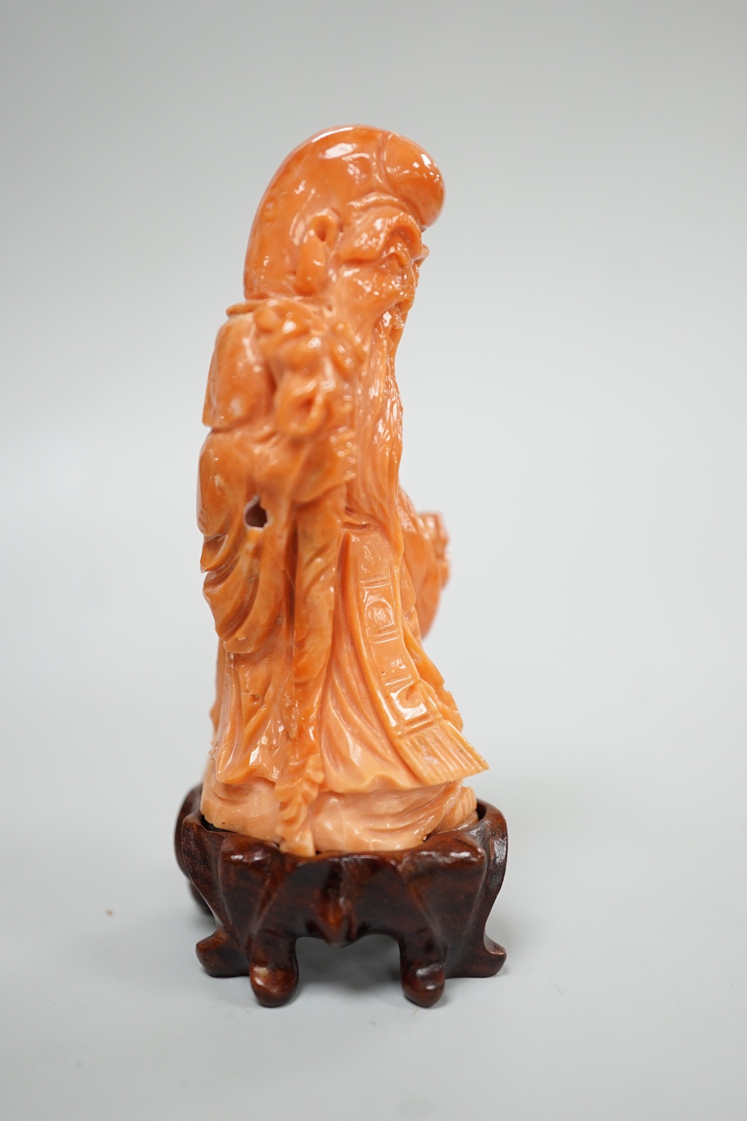 A Chinese coral figure of Shou Lao, 20th century, 7.4 cm high, 73g, wood stand